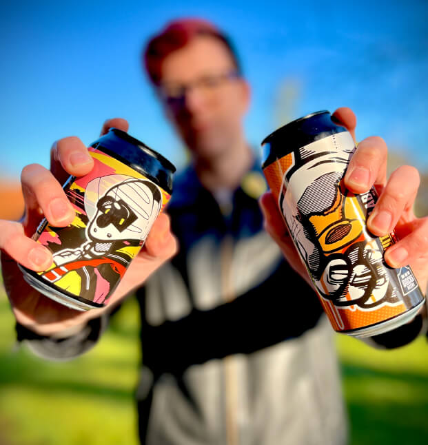 Kirk Arnold, designer at Sourcefour holding a can of Docks Beers "Fruits Of Our Labour" and "Low Tide"