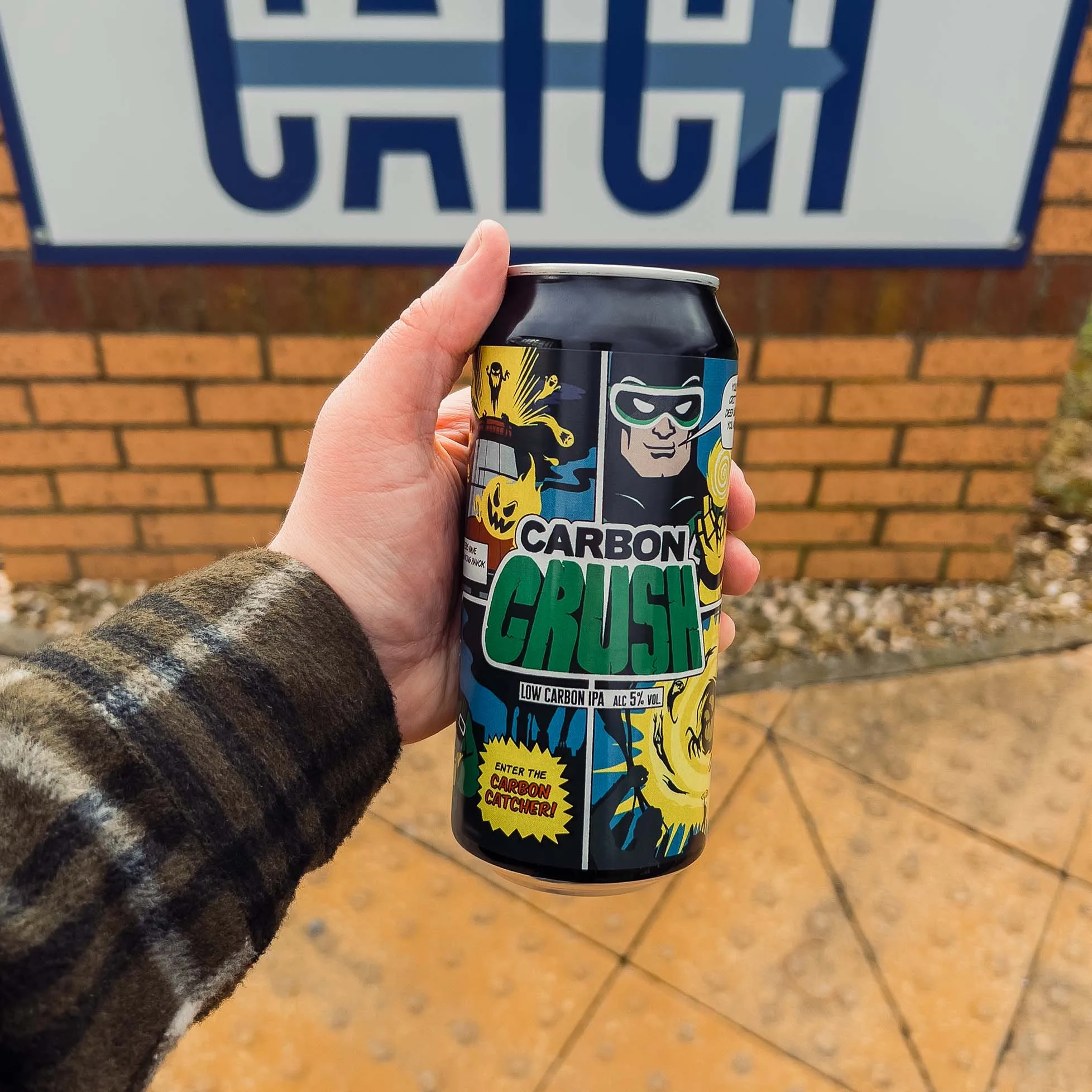 A person raising awareness of industrial decarbonisation by holding up a can of aardvark green.