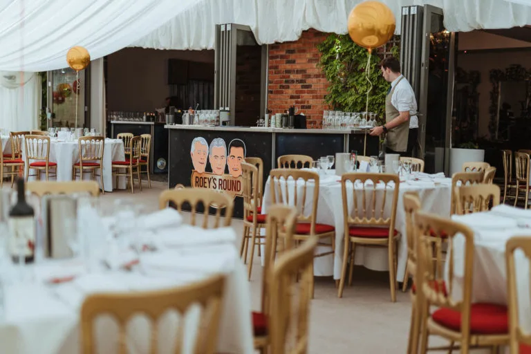 A tented wedding reception with tables and chairs.