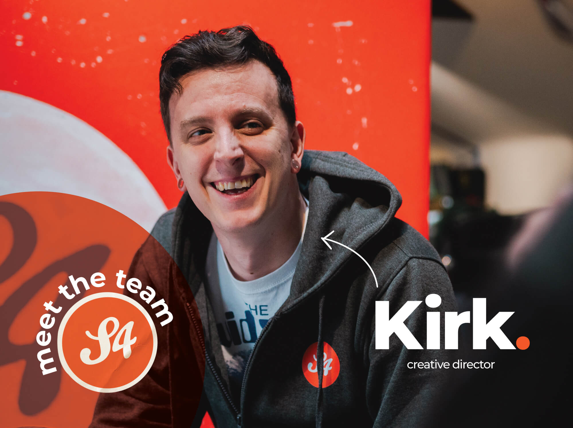 Meet the S4 Team - Sourcefour Creative Director Kirk laughing in the studio on an orange backdrop.
